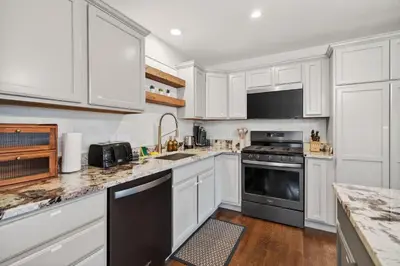 a kitchen with white cabinets and black appliances at The Willowbrook Catskills in Athens