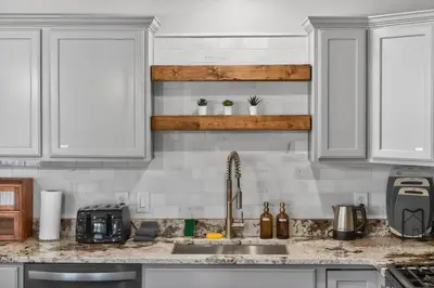 a kitchen with white cabinets and a sink at The Willowbrook Catskills in Athens