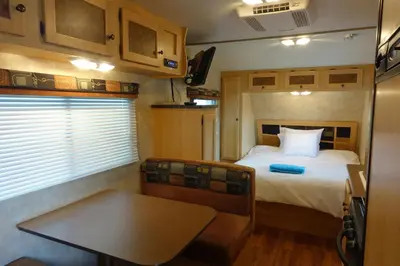 a bedroom with a bed and a table in a trailer at Best RV-Camper To Visit NYC-Hot Tub-Free Parking in Hillside
