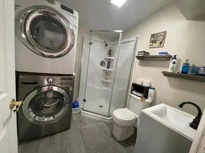 a bathroom with a washing machine and a shower at Cheerful two bedroom bungalow near Mountain Creek in West Milford