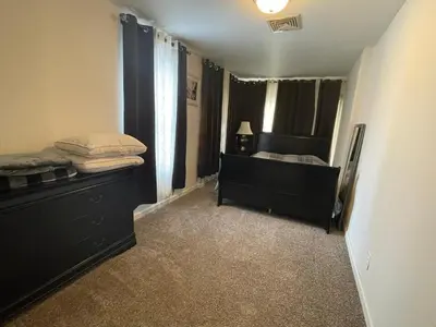 a bedroom with a bed and a dresser and a window at Cheerful two bedroom bungalow near Mountain Creek in West Milford