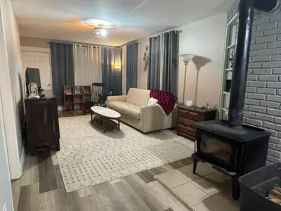 a living room with a couch and a stove at Cheerful two bedroom bungalow near Mountain Creek in West Milford
