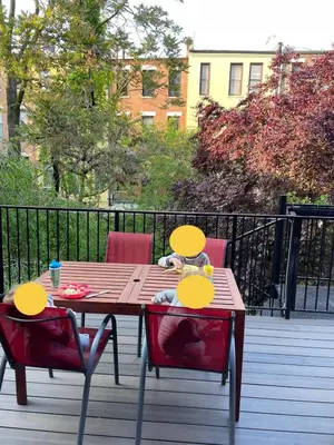 a wooden table and two chairs on a deck at Elegant Historic Harlem Townhouse Apartments for Summer in New York
