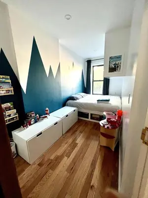 a small bedroom with a bed and a desk at Elegant Historic Harlem Townhouse Apartments for Summer in New York