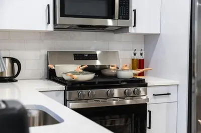 a kitchen with three bowls on top of a stove at 20 Minutes to Times Square, Stylish 2 Bedroom Apartment in West New York