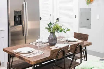 a wooden table in a kitchen with a vase at 20 Minutes to Times Square with Free Indoor Parking in West New York