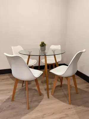 a dining table and chairs with a glass table and white chairs at Spacious Apt 15 mins to NYC with Free Indoor Parking in West New York