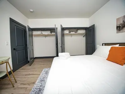 a bedroom with a large white bed with two doors at Excellent Location-20 Minutes to NYC-Free Parking in West New York