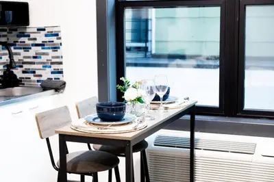 a table in a kitchen with glasses and plates at Discover NYC in stylish Studio-25 mins to NYC in West New York