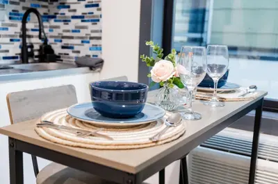 a table with plates and wine glasses on it at Discover NYC in stylish Studio-25 mins to NYC in West New York