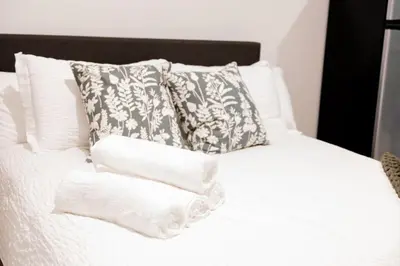 a white bed with pillows and towels on it at Discover NYC in stylish Studio-25 mins to NYC in West New York