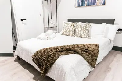 a bedroom with a large bed with a brown blanket at Discover NYC in stylish Studio-25 mins to NYC in West New York
