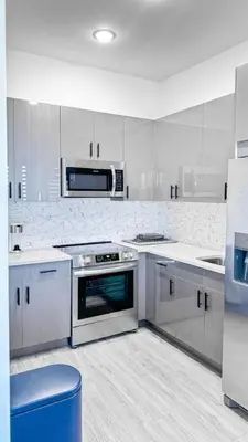 a kitchen with white cabinets and a stove top oven at Stylish Studio Apt-Outside NYC in West New York