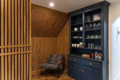 a room with a chair and a blue cabinet at Bright, Cozy, and Peaceful Two Bedroom Apt Near NYC in North Bergen