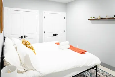 a bedroom with white walls and a bed with white sheets at City Adventure-Quick NYC Access-2BR-Free Parking in West New York