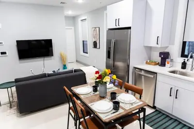 a kitchen and living room with a table and a couch at Quick NYC Access with Free Parking Two Bedrooms Near NYC in West New York