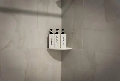 three bottles of wine sitting on a shelf in a bathroom at Bright Apartment with Free Parking Near NYC in West New York