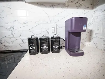three coffee cups sitting on a counter next to a coffee maker at Prime Location with Free Parking Near NYC in West New York