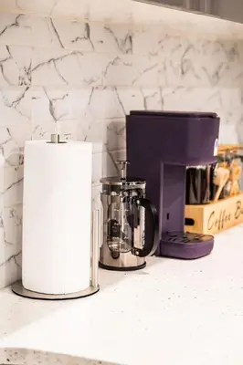 a kitchen counter with a coffeemaker and a coffee maker at Two Bedrooms with Free Parking Near NYC in West New York