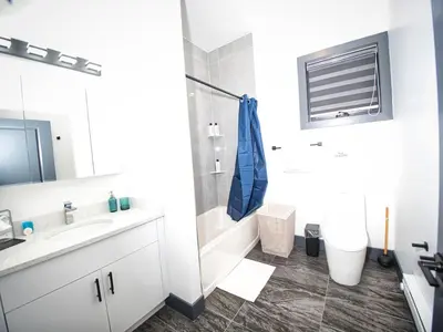 a white bathroom with a sink and a shower at Explore New York City-20 Minutes Away With Parking in West New York