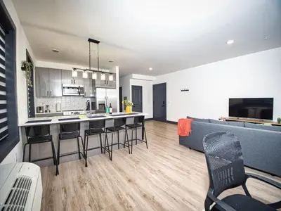 a kitchen and living room with a couch and a bar at Great Location-20 Mins to NYC-Free Indoor Parking in West New York