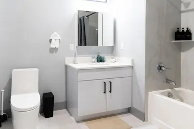 a bathroom with a sink and a toilet and a mirror at 2 Bedroom Apt-City Adventure-Free Parking on Site in West New York