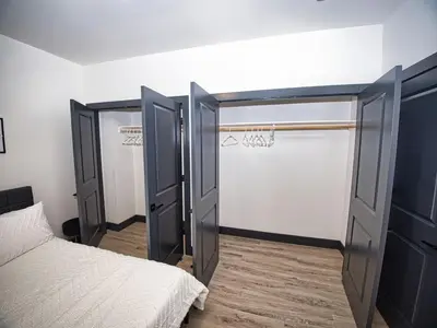 a closet with two doors and a bed in a room at Free Indoor Parking 25 Minutes to NYC in West New York