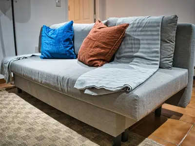 a couch with pillows on it in a living room at Cozy Apt With King Size Bed- Only 5 Miles to NYC in North Bergen