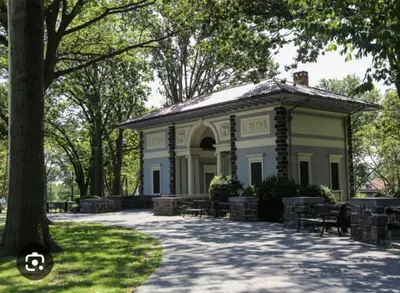 a building in a park with a tree at Cozy Apt With King Size Bed- Only 5 Miles to NYC in North Bergen