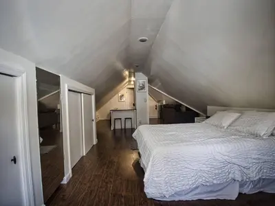 a bedroom with a white bed in a attic at Comfy 3rd Floor Studio Near NYC in Ridgefield Park