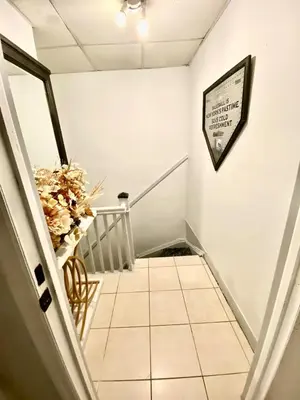 a hallway with a staircase with a sign on the wall at Private room B in West NYNJ 12mints from NYCity Times Square in West New York