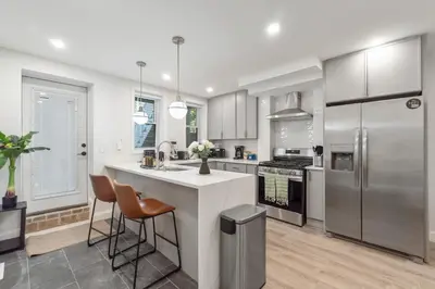 a kitchen with white cabinets and a white counter top at Cozy 1BR level apartment w patio & workstation in Jersey City