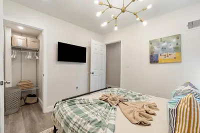 a bedroom with a bed and a tv on the wall at Holiday Home Brownstone City Stay 5BEDS, Private Dual Units in Jersey City