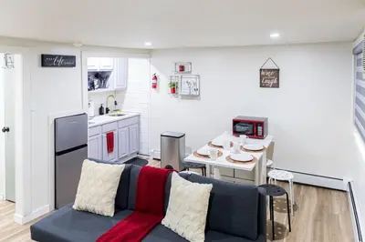 a living room with a couch and a kitchen at Cozy and Convenient Studio with 3 beds 10 Minutes to NYC in Union City