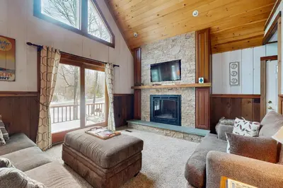a living room with a fireplace and a tv at Owls' Hollow in West Dover