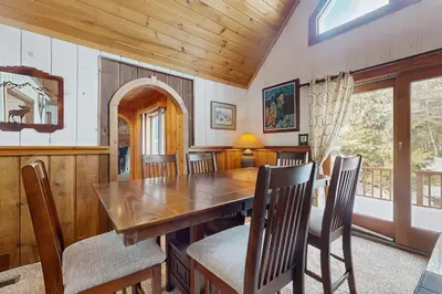 a dining room with a wooden table and chairs at Owls' Hollow in West Dover
