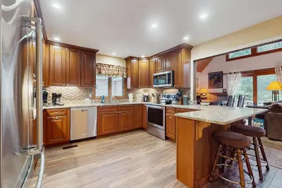 a large kitchen with wooden cabinets and a counter at Owls' Hollow in West Dover