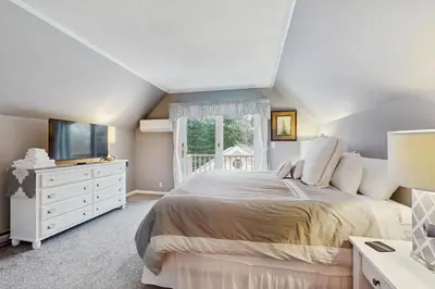a bedroom with a large bed and a window at Owls' Hollow in West Dover