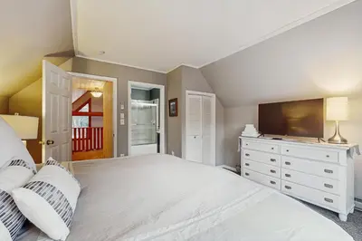 a bedroom with a white bed and a television at Owls' Hollow in West Dover