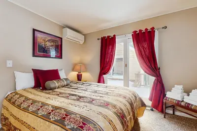 a bedroom with a bed with red curtains and a window at Owls' Hollow in West Dover