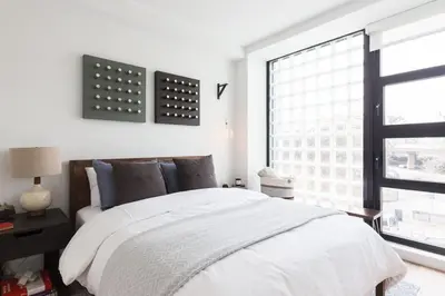 a bedroom with a white bed and a window at Union Residence by Rove - Gorgeous Williamsburg Condo in Brooklyn