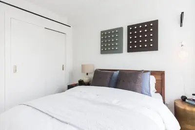 a white bedroom with a white bed and a window at Union Residence by Rove - Gorgeous Williamsburg Condo in Brooklyn