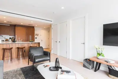 a living room with a black chair and a table at Union Residence by Rove - Gorgeous Williamsburg Condo in Brooklyn