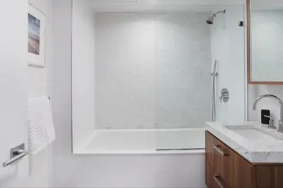 a white bathroom with a tub and a sink at Union Residence by Rove - Gorgeous Williamsburg Condo in Brooklyn