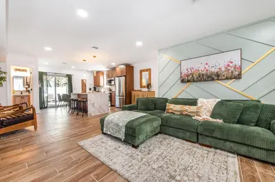 a living room with a green couch and a kitchen at Luxury Apartment in Irvington in Irvington