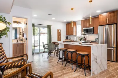 a kitchen with wooden cabinets and a counter with bar stools at Luxury Apartment in Irvington in Irvington