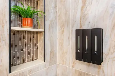 a bathroom with black wall niches and a plant at Luxury Apartment in Irvington in Irvington