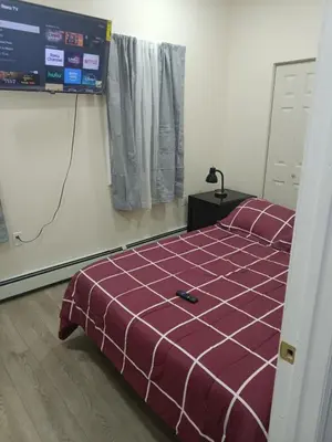 a bedroom with a bed with a purple comforter at Luxury private room bath WiFi in Troy