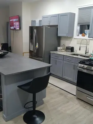 a kitchen with stainless steel appliances and a black chair at Luxury private room bath WiFi in Troy