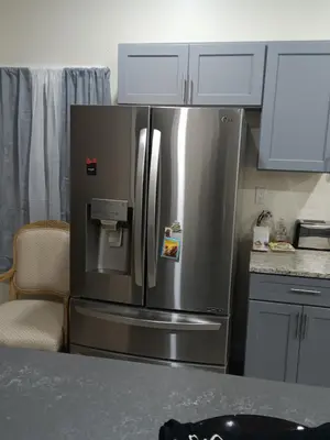 a stainless steel refrigerator in a kitchen with white cabinets at Luxury private room bath WiFi in Troy